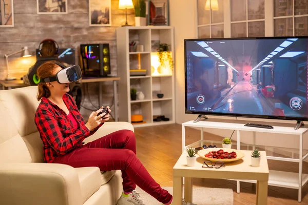 Vrouw gamer spelen video games met behulp van een Vr headset laat op de avond — Stockfoto