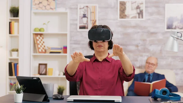 Retired senior woman amazed while using virtual reality goggles — Stock Photo, Image