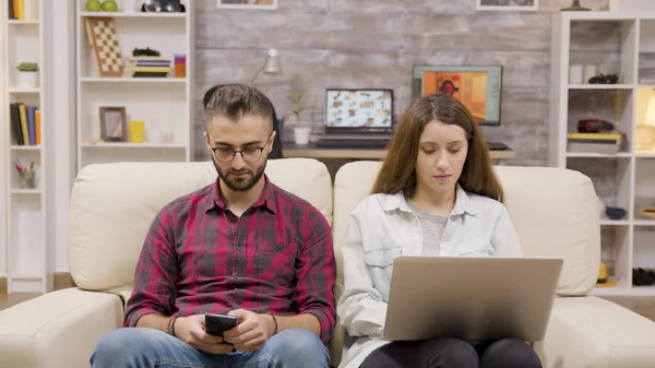 Красивая пара, сидящая на диване и делающая покупки онлайн — стоковое фото
