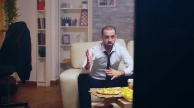 Revealing shot of businessman in suit watching a game