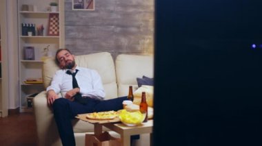 Young businessman in suit falling asleep on the couch