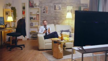 Young businessman in suit and tie relaxing drinking beer
