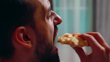 Close up of entrepreneur eating a slice of pizza