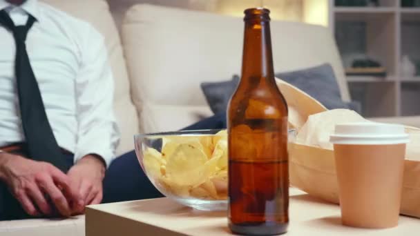 Businessman relaxing at home drinking beer — Stock video