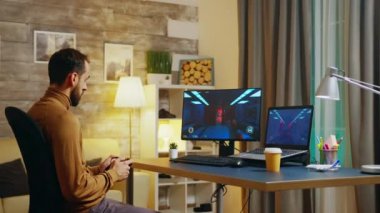 Sakallı mühendis joystick ile video oyunu oynuyor.