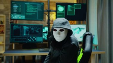 Masked hacker wearing a hoodie to hide his identity
