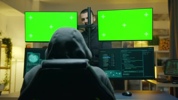 Team of hackers using computer with green screen mockup — Stockvideo