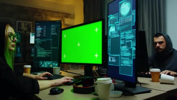 Zoom en la toma de la chica hacker en frente de la computadora con pantalla verde — Vídeos de Stock