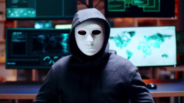 Zoom in shot cyber criminal wearing a white mask — Stockvideo