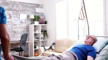 Beautiful caucasian doctor helping old man in nursing home