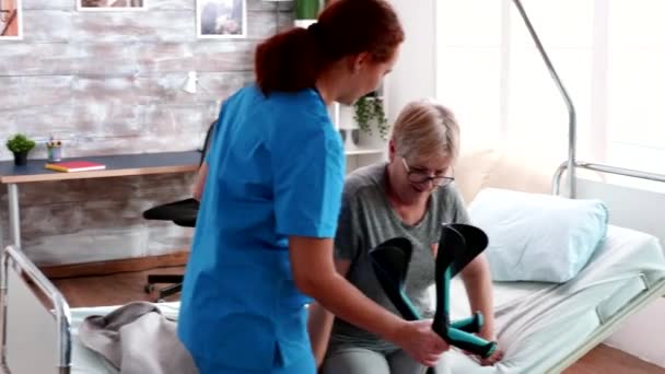 Female doctor helping old woman with walking disability — 비디오