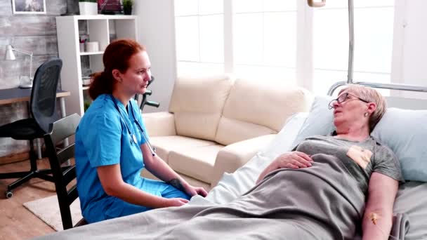 Vecchia donna in pensione sdraiata sul letto in casa di cura — Video Stock