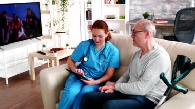 Female caregiver helping old man in nursing home