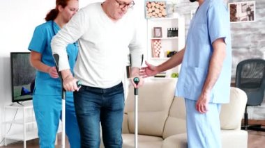 Retired old man in nursing home getting help from professional social workers