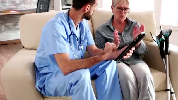 Male nurse holding tablet computer in retirement home — Stock video