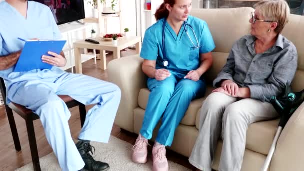 Enfermera masculina escribiendo procedimiento de rehabilitación — Vídeos de Stock