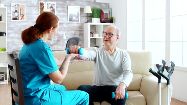 Terapia de rehabilitación muscular: la enfermera está ayudando a un anciano discapacitado a ganar fuerza — Vídeo de stock