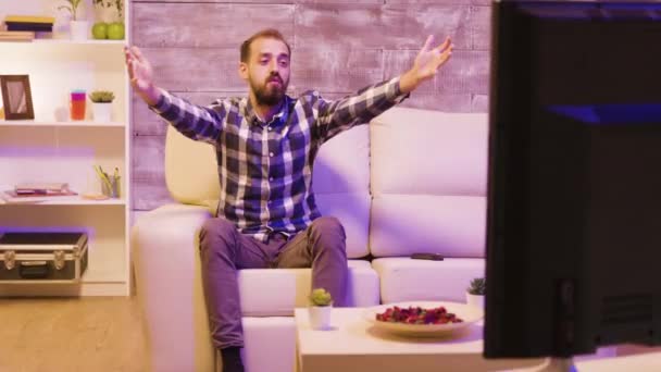 Homem barbudo sentado no sofá assistindo tv e aplaudindo — Vídeo de Stock