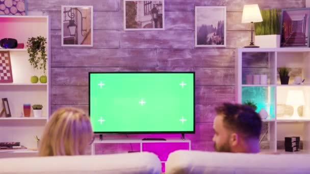 Cheerful couple relaxing on the couch and playing video games — Stockvideo