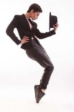 Stüdyoda beyaz arka planda şık bir şapkayla Michael Jackson gibi poz veren güzel, genç bir manken.