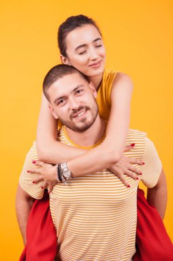 Güzel kız arkadaş gözleri kapalı, erkek arkadaş ise sırtında taşır.