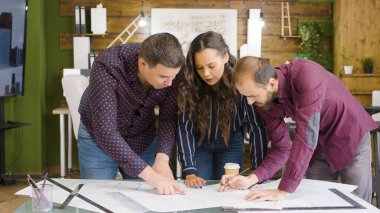 Modern ve rahat ofis ekibinde mimarlar ve tasarımcılar çalışıyor.