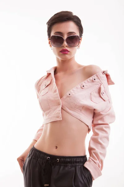 Stylish young female posing in studio wearing a pink jacket over white background — Stock Photo, Image