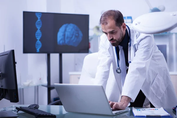 뇌 영상을 배경으로 노트북을 사용하는 의사 — 스톡 사진