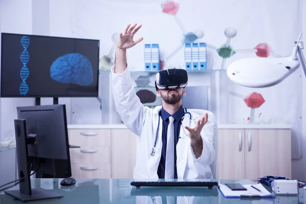 Молодий чоловік лікар проводить медичну процедуру в гарнітурі віртуальної реальності — стокове фото