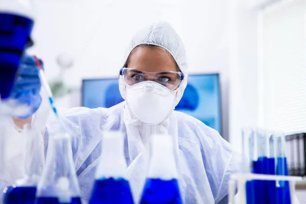Vista de perto do cientista que tira uma amostra de solução azul — Fotografia de Stock