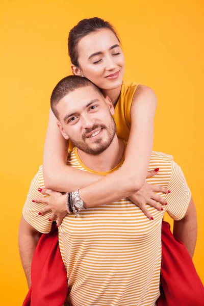 Bela namorada com os olhos fechados, enquanto namorado ofer um piggyback — Fotografia de Stock