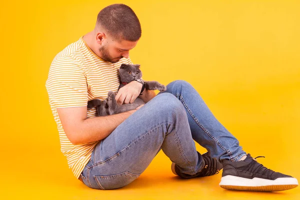 Handsome young man holding and loving his cat — Stock Photo, Image