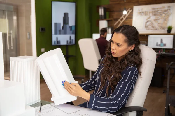 Женщина-архитектор в современном офисе рассматривает 3D-модель здания — стоковое фото