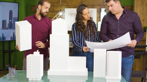 Equipo de arquitectos trabajando con planos y modelos impresos en 3D de edificios —  Fotos de Stock