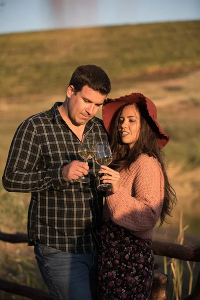 浪漫的夫妻日落时在葡萄园里喝酒 — 图库照片