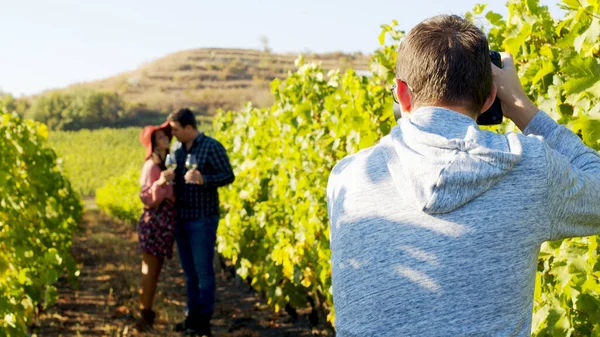 Фотограф фотографує милу пару в винограднику — стокове фото