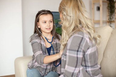 Worried little girl using stethoscope