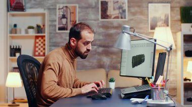 Young engineer working late at night in his home office