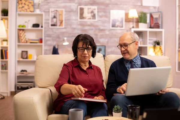 Grootmoeder en grootvader die een laptop gebruiken om met hun kleinzonen te chatten — Stockfoto