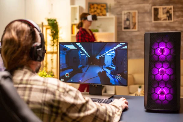 Visão traseira do jogador de vídeo profissional jogando no PC poderoso tarde da noite na sala de estar — Fotografia de Stock