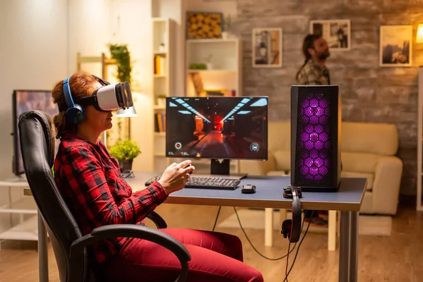 Női játékos használ VR headset játszani videojátékok késő este a nappaliban — Stock Fotó