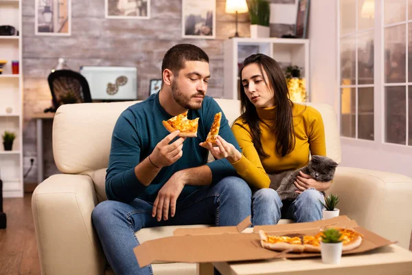 Nádherný mladý pár jíst pizzu při sledování televize — Stock fotografie