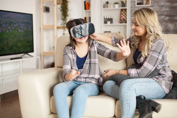 Little girl playing video games using virtual reality goggles — Stock fotografie