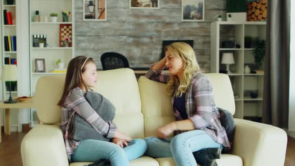 Красива молода мати сидить на дивані у вітальні — стокове відео