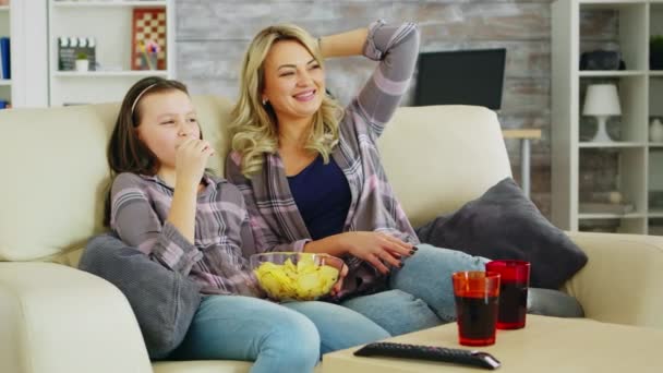 Niña comiendo patatas fritas mientras ve la película en la televisión — Vídeos de Stock