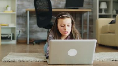 Oturma odasında yerde uzanmış diş telleri olan küçük bir kız.