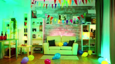 Parti dekore edilmiş duvarında neon ışıklar ve disko topu olan bir oda.