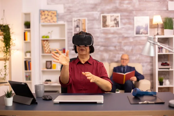 Mulher idosa idosa usando um fone de ouvido de realidade virtual VR pela primeira vez — Fotografia de Stock
