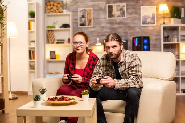 Oyuncular, ellerinde kablosuz kontrolörlerle TV 'de video oyunu oynuyorlar. — Stok fotoğraf