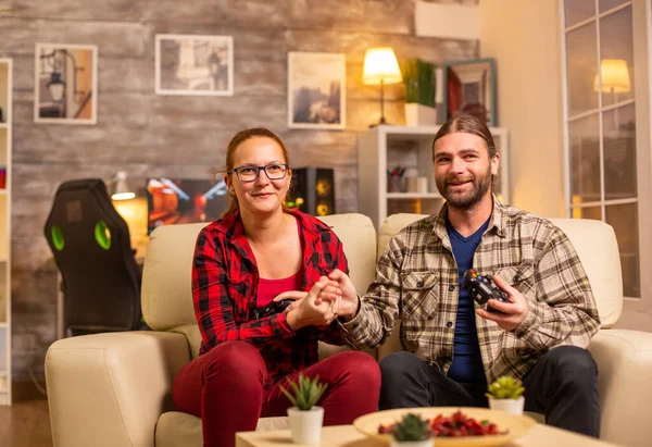 Spelare par spelar tv-spel på Tv med trådlösa styrenheter i händerna — Stockfoto